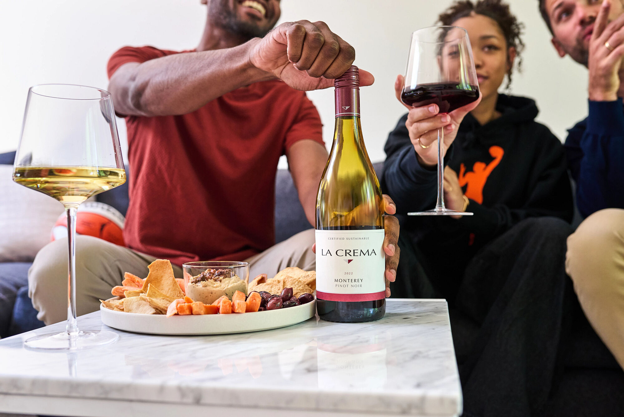 Friends opening a bottle of La Crema Pinot Noir